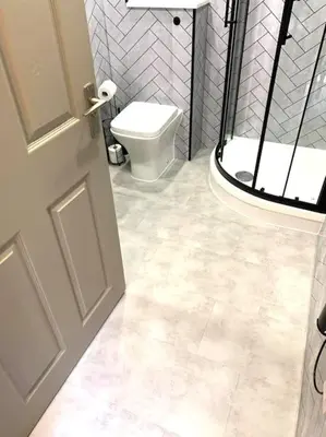 a bathroom with a white toilet and a door at Grassmarket Apartment in Edinburgh