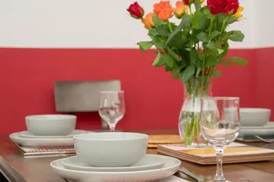 a dining room table with a vase of flowers and glasses at Banrigh House in Stirling