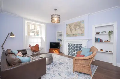 a living room with a couch and chairs and a fireplace at Banrigh House in Stirling