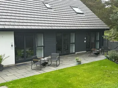 a patio with chairs and tables in a yard at Beechwood in Oban