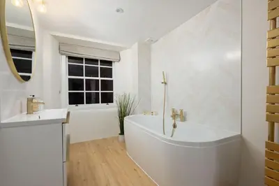 a white bathroom with a tub and a sink at Escape to Serene Georgian Estate, near Edinburgh in Ratho