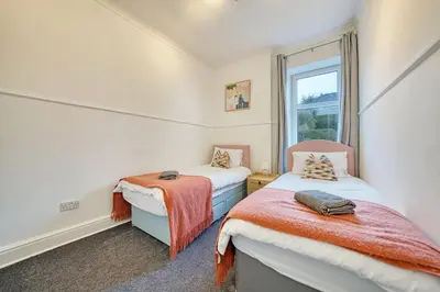 two beds in a room with a window at 3BR Flat Near Maryhill Park and West End with Parking in Partick