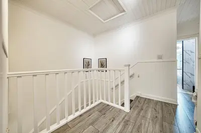 a white staircase in a home with white walls and wooden floors at 3BR Flat Near Maryhill Park and West End with Parking in Partick
