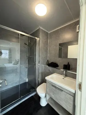 a bathroom with a shower and a sink and a toilet at Luxurious 2 bedroom, 8 mins from city centre in Glasgow