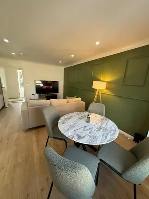 a living room with a table and chairs and a couch at Luxurious 2 bedroom, 8 mins from city centre in Glasgow