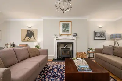 a living room with a couch and a fireplace at Elegant Flat with Garden in Edinburgh West End in Edinburgh