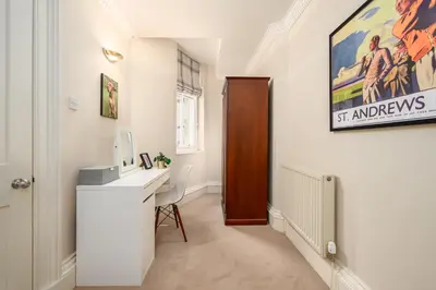 a home office with a desk and a painting on the wall at Elegant Flat with Garden in Edinburgh West End in Edinburgh