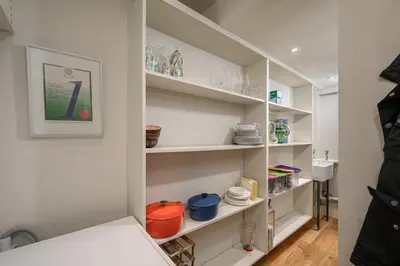 a room with white shelves with dishes on them at Elegant Flat with Garden in Edinburgh West End in Edinburgh