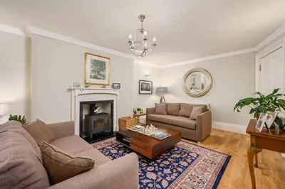 a living room with two couches and a fireplace at Elegant Flat with Garden in Edinburgh West End in Edinburgh