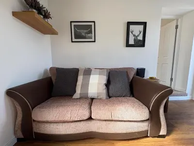 a brown couch sitting in a living room at Muirside Cottage in Stirling