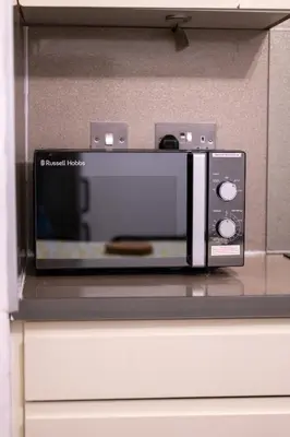 a microwave oven sitting on top of a counter at Sauchihall Apartment in Glasgow