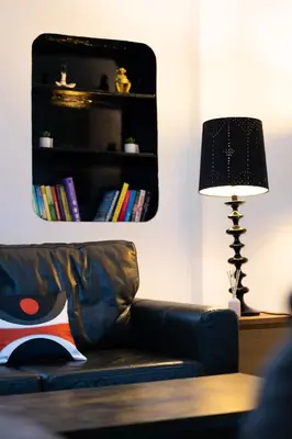 a living room with a leather couch and a lamp at Sauchihall Apartment in Glasgow