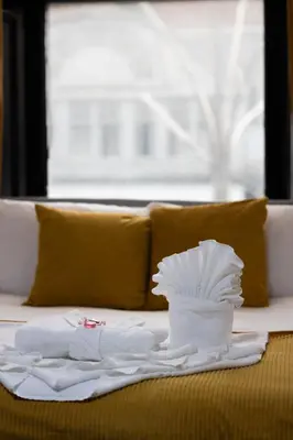 a pile of white towels on a bed with a window at Sauchihall Apartment in Glasgow