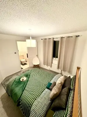 a bedroom with a large bed and a couch at Tartan Nest- Entire house- Sleeps 8 guests in Mansewood