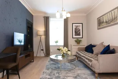 a living room with a couch and a table at Cosy 1-Bedroom Flat, Walk to Beaches in Troon
