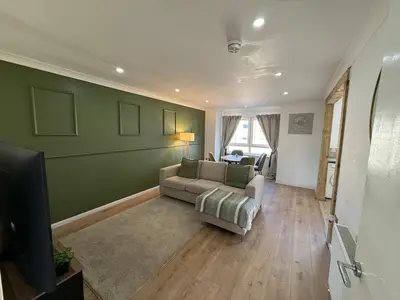 a living room with a couch and a television at Luxurious 2BR, 8 mins from centre in Glasgow