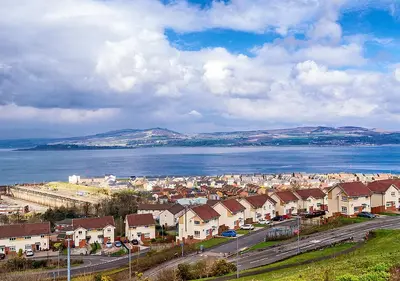 an aerial view of a town with houses and the water at Silver Tides House in Greenock