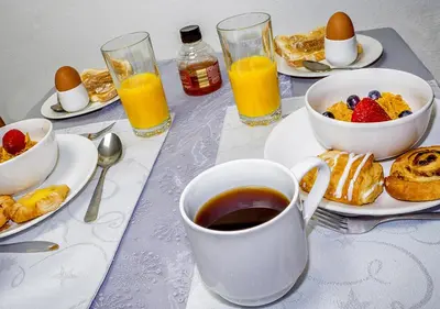 a table with breakfast foods and a cup of coffee at Silver Tides House in Greenock