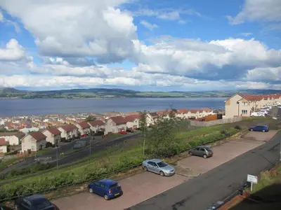 a city with cars parked in a parking lot at Silver Tides House in Greenock