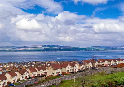 a row of houses next to a large body of water at Silver Tides House in Greenock