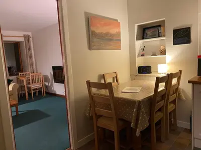 a dining room with a table and chairs and a kitchen at Allt-Na-Craig Coach House - Ardrishaig in Ardrishaig