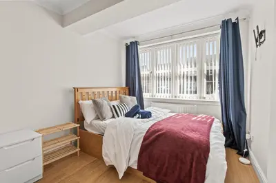 a bedroom with a bed and a window at Polmont Haven: Spacious 4- Bedroom Retreat in Polmont