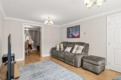 a living room with a couch and a chair at Polmont Haven: Spacious 4- Bedroom Retreat in Polmont