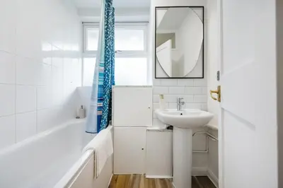 a bathroom with a sink and a tub and a mirror at Cozy 2 bedroom London Flat in Heart of Pimlico in Moffat