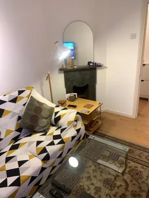 a living room with a couch and a table at Elegant, Cozy 1 Bedroom Flat In Heart Of London Pimlico in Moffat
