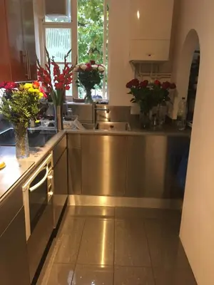 a kitchen with vases of flowers on the counter at Elegant, Cozy 1 Bedroom Flat In Heart Of London Pimlico in Moffat