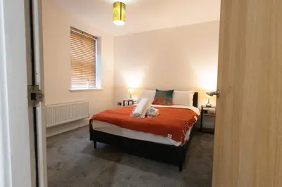 a bedroom with a bed with a teddy bear on it at Buchanan Penthouse in Glasgow