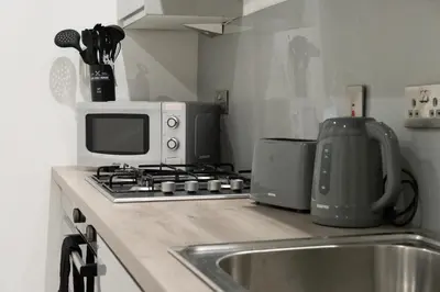 a kitchen counter with a microwave and a sink at Buchanan Penthouse in Glasgow