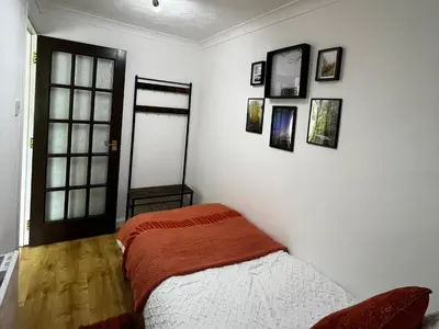 a bedroom with a bed and pictures on the wall at Tickety-Boo Luss Loch Lomond in Luss
