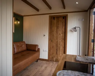 a living room with a couch and a table at Pentland Shepherd Huts in Penicuik