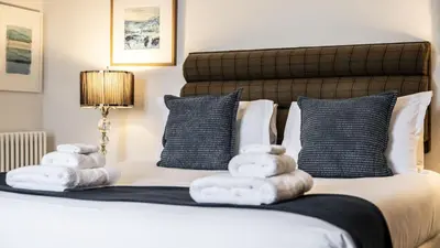 a bedroom with a bed with towels on it at Cairns Farmhouse in Kirknewton