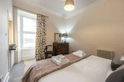 a bedroom with a bed with two towels at Cairns Farmhouse in Kirknewton