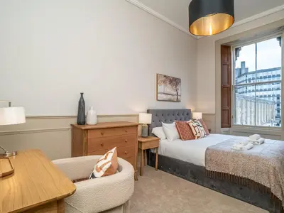 a bedroom with a bed and a desk and a chair at Pass the Keys Beautiful Modern Historical Flat Close to Castle in Edinburgh