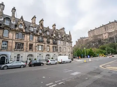 a street with cars parked in front of a building at Pass the Keys Beautiful Modern Historical Flat Close to Castle in Edinburgh