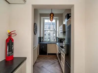 a kitchen with a red fire extinguisher in a room at Pass the Keys Beautiful Modern Historical Flat Close to Castle in Edinburgh