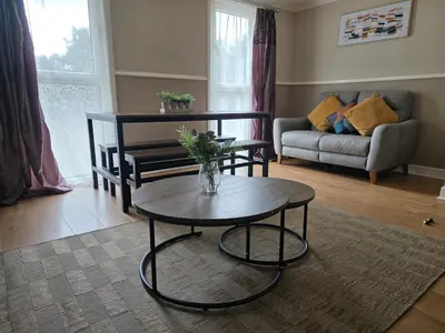 a living room with a table and a couch at 3BR House with Parking 10 Mins to Airport Sleeps 6 in EDI