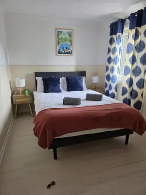 a bedroom with a large bed with blue pillows at 3BR House with Parking 10 Mins to Airport Sleeps 6 in EDI