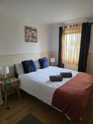 a bedroom with a large bed with two pillows on it at 3BR House with Parking 10 Mins to Airport Sleeps 6 in EDI
