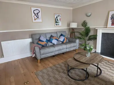a living room with a couch and a table at 3BR House with Parking 10 Mins to Airport Sleeps 6 in EDI