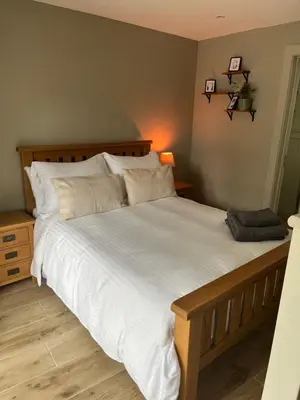 a bedroom with a large bed with white sheets and pillows at Kilmory Sea View in Lochgilphead