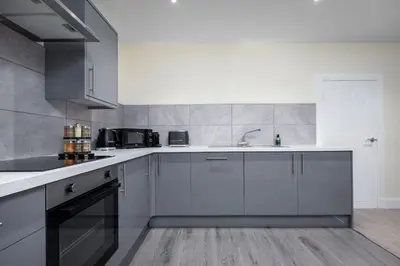 a kitchen with white cabinets and a sink at Stirlings Hidden and Tranquil Studio Apartment in Stirling