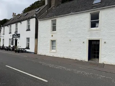 a white building on the side of a street at Watt-A-View in Limekilns