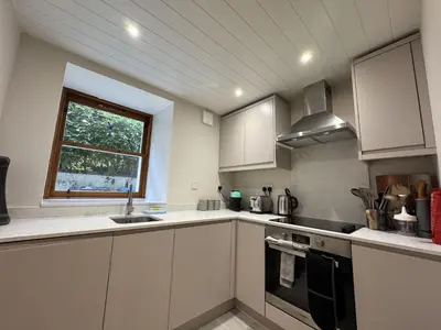 a kitchen with white cabinets and a sink and a window at Watt-A-View in Limekilns