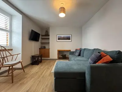 a living room with a blue couch and a table at Watt-A-View in Limekilns