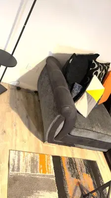 a couch with pillows on it in a room at The friendly place in Glasgow