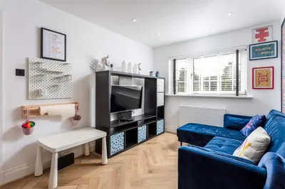 a living room with a blue couch and a tv at No22 Shalloch House - Donnini Apartments in Ayr